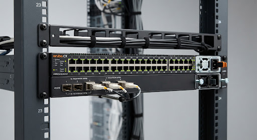 HPE Aruba CX 6300M series modular switch device showing multi-gigabit ethernet ports and four SFP56 uplink sockets in rack layout shot against studio lighting